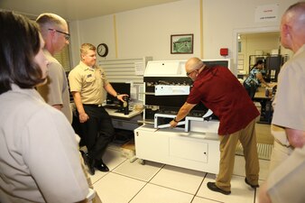 230510-N-YR423-6256 PENSACOLA, Fla. –Navy Advancement Center employee Carlos Carey shows the Naval Education and Training Command (NETC) domain fiscal year 2022 Sailor of the Year (SOY) candidates and their command master chiefs the scantron machine during their visit to Naval Education and Training Professional Development Center (NETPDC) headquarters onboard Saufley Field in Pensacola, Florida, May 10, 2023. During their visit, the SOY candidates and their master chiefs learned how NAC employees process over 290,000 Navy-wide advancement exam answer sheets each year. (U.S. Navy photo by Cheryl Dengler)