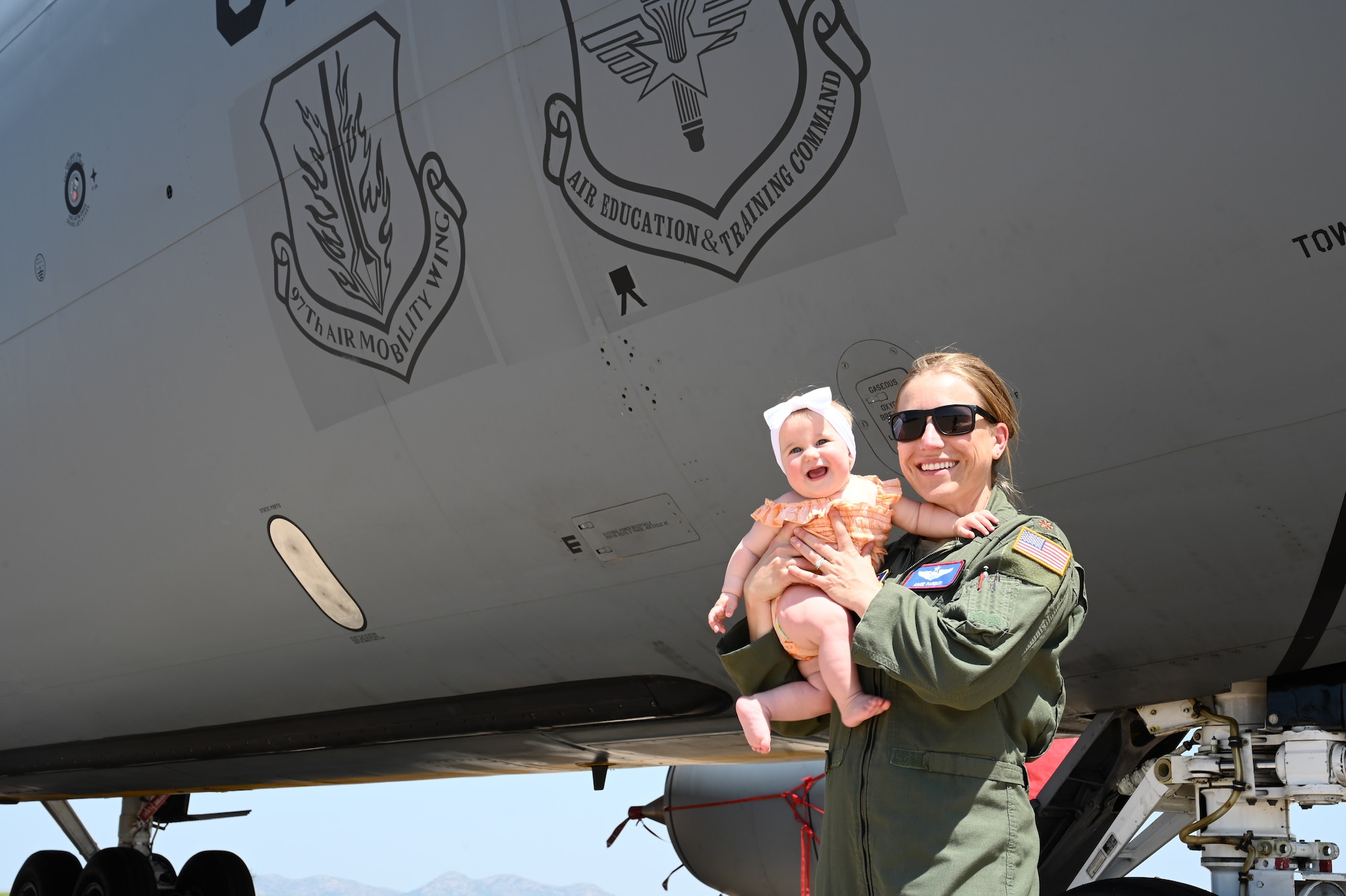 U.S. Air Force Maj. Aimee Parenti, 54th Air Refueling Squadron formal training unit instructor pilot, poses for a photo with her daughter, Gemma, at Altus Air Force Base, Oklahoma, May 8, 2023. Women first entered pilot training in 1976, navigator training in 1977 and fighter pilot training in 1993. (U.S. Air Force photo by Senior Airman Kayla Christenson)