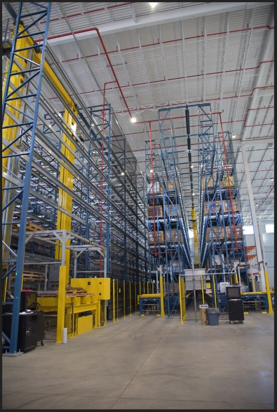 A large warehouse with metal racks reaching up three stories.