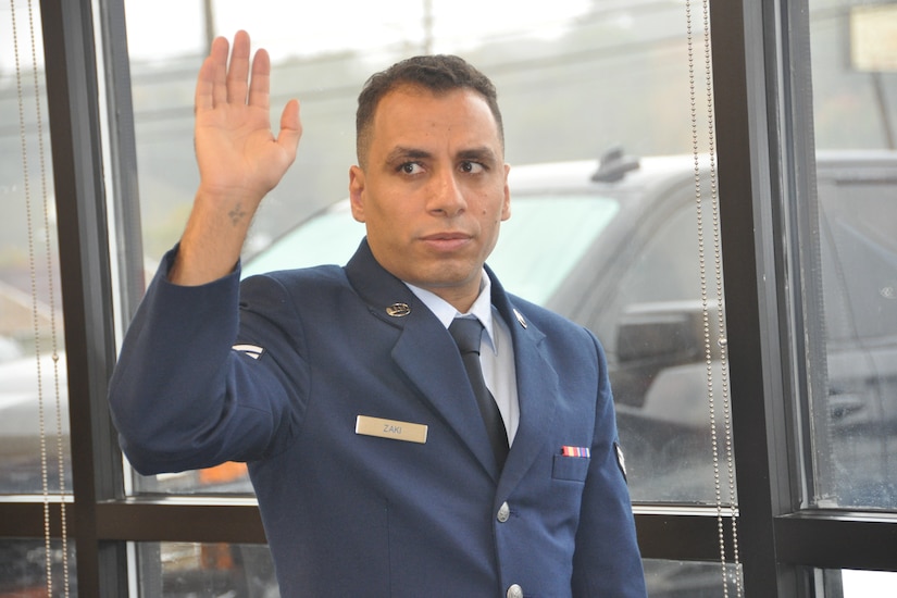 An airman raises his right arm.