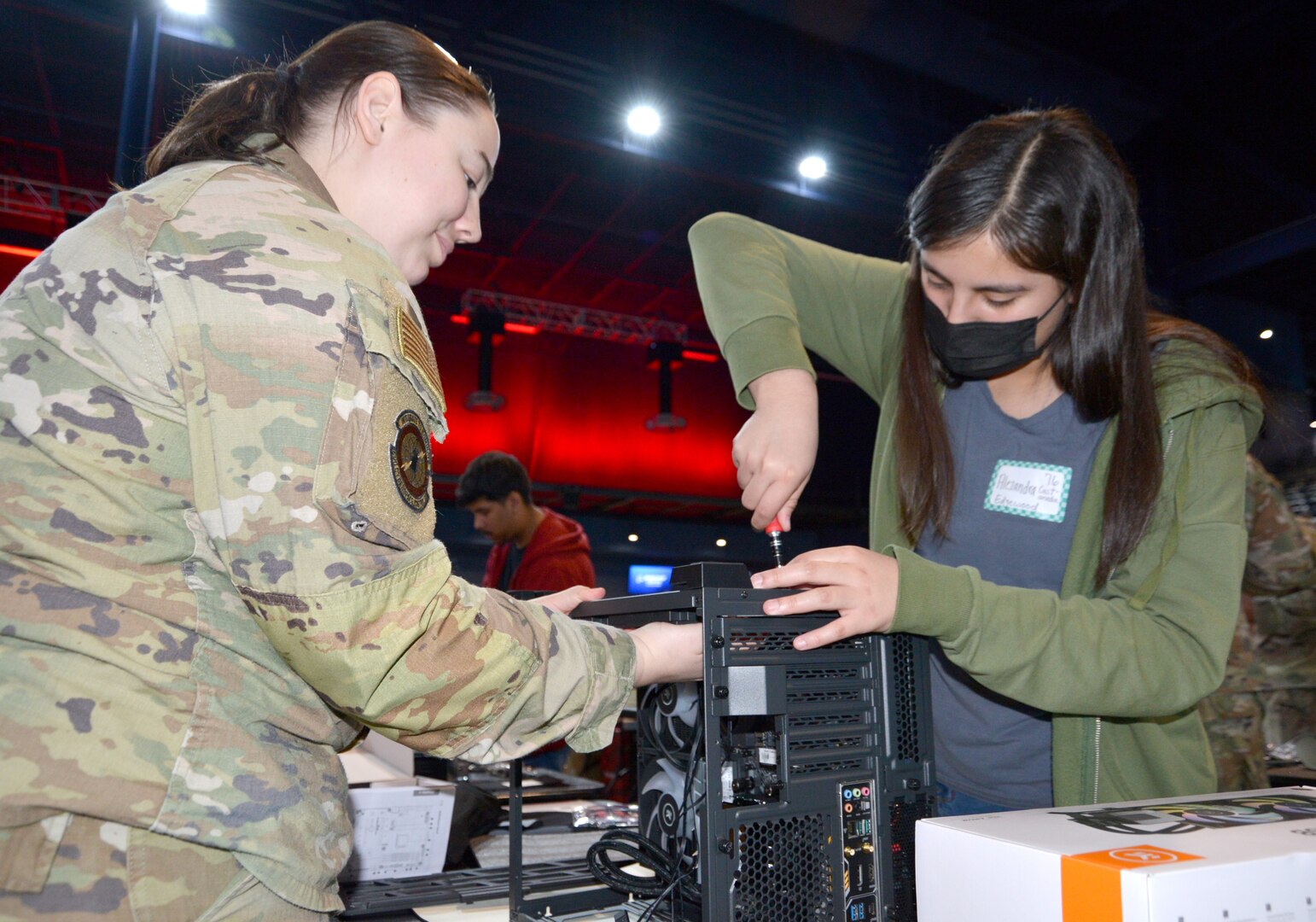 Master Sgt. Danielle Loomis, 688th Cyber Wing Network Operations Cell section chief assists Alezandra Castaneda, from John F. Kennedy High School, with attaching a component during the ‘Build Your Future’ event, April 29, 2023, at Tech Port Arena, in San Antonio, Texas. Loomis and the other 19 mentors displayed military expertise and inspired students to pursue cyber in the military, with industry partners, or academia.