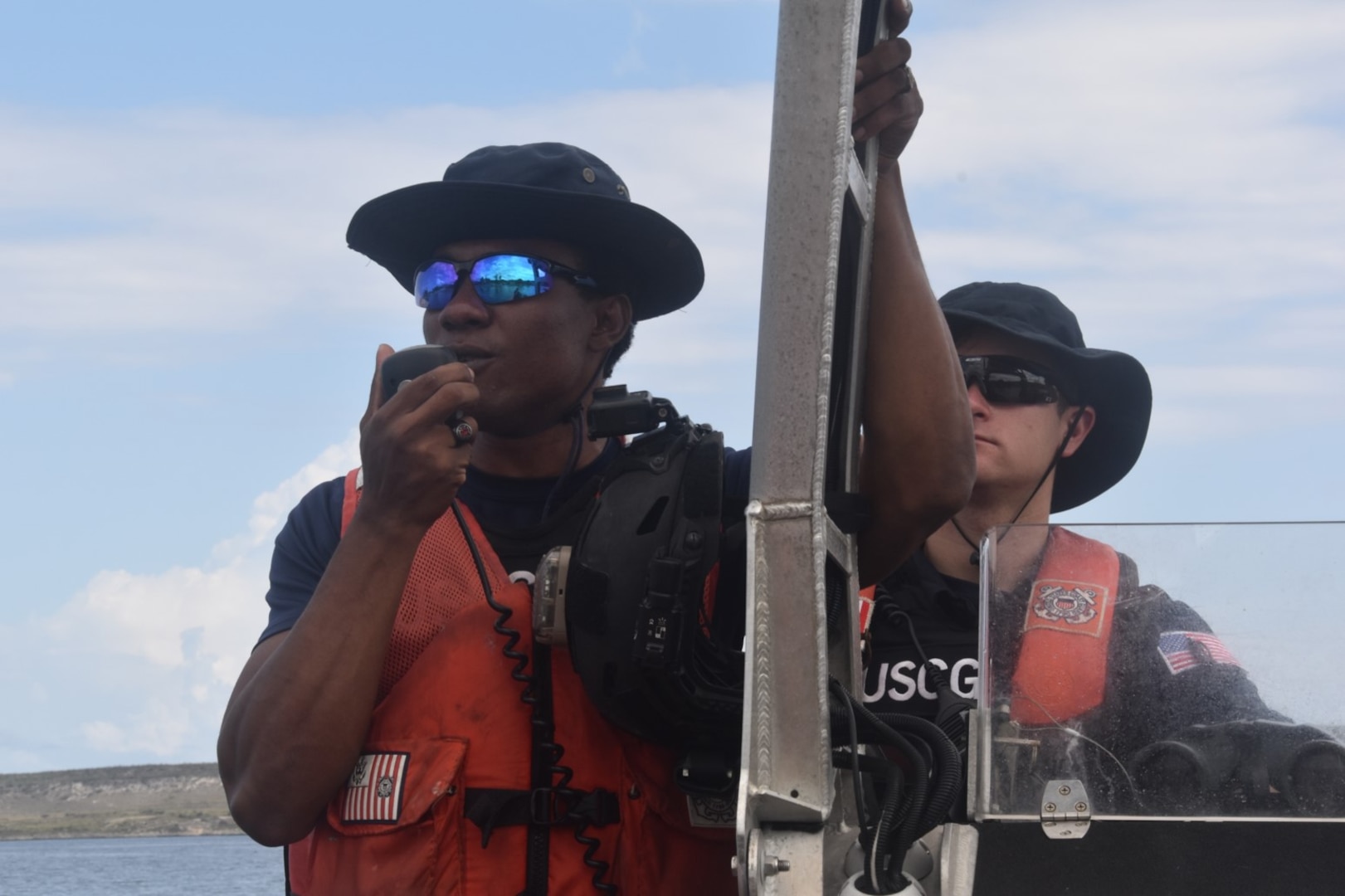 Haitian Coast Guard Officer Josue Philogene addresses migrants alongside the USCGC Campbell (WMEC 909) crew to deter migrant vessel ventures at sea, April 18, 2023. While underway in the Seventh Coast Guard District’s area of responsibility, Campbell’s crew conducted maritime safety and security missions while working to detect, deter and intercept unsafe and illegal maritime migration ventures bound for the United States. (U.S. Coast Guard photo by Petty Officer 2nd Class Stephen Touchton)