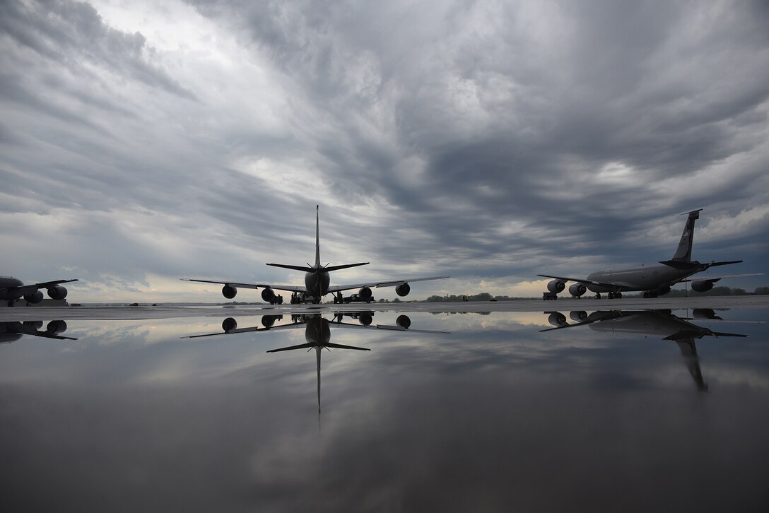 Military aircraft are parked at an airport during overcast weather.