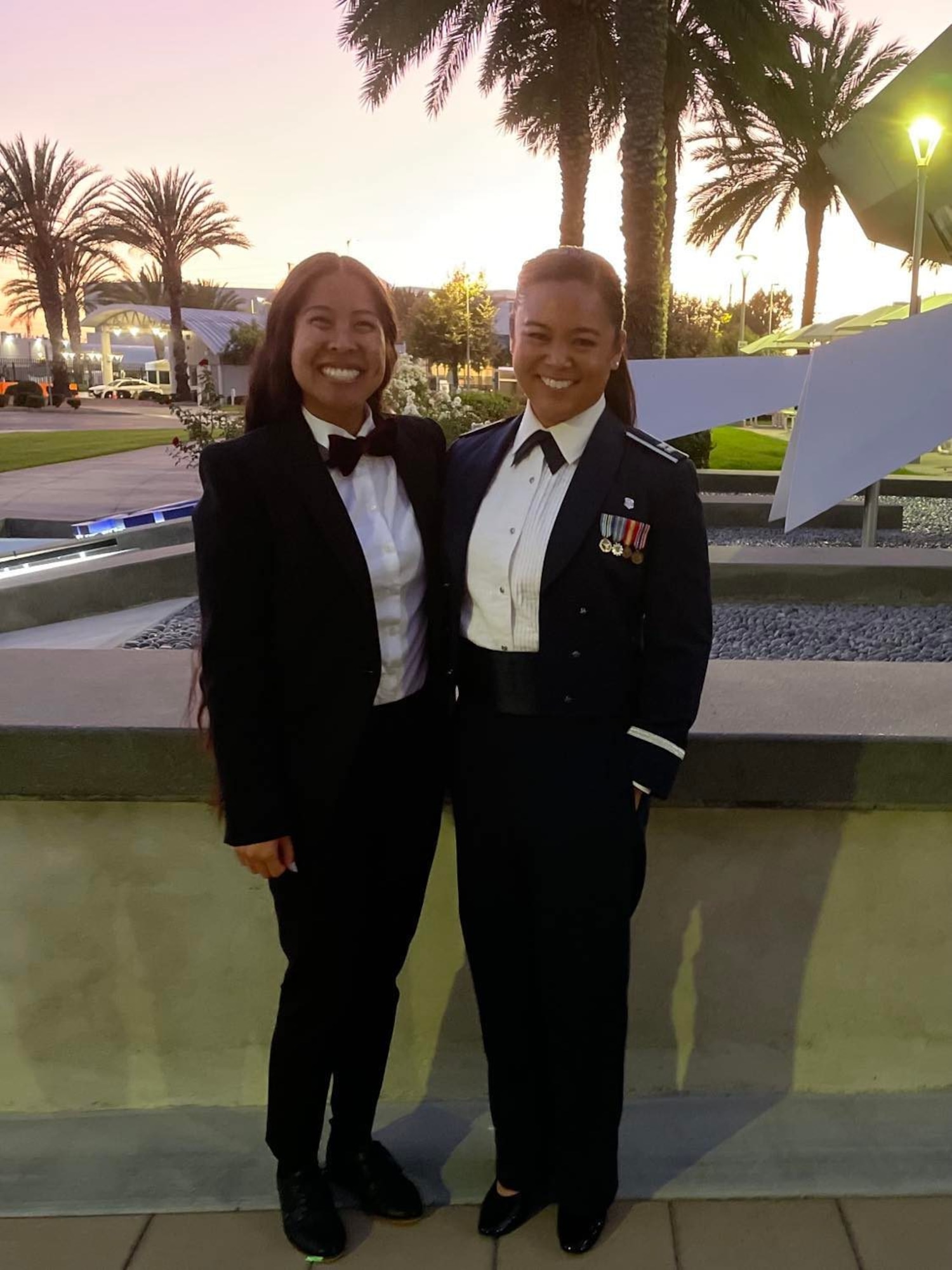 Capt. Joi Renee Athanaxay and her spouse, Lexie Athanaxay pose for a photo in front of the Delta Feature at Los Angeles Air Force Base, Calif.