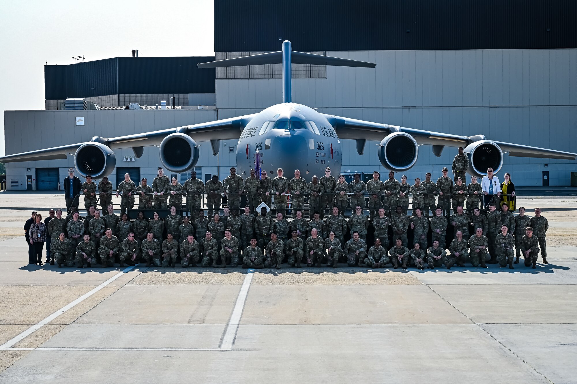 U.S. Air Force Airmen assigned to the 305th Air Mobility Wing pose for a flight line photo on 10 May, 2023 at Joint Base McGuire-Dix-Lakehurst, N.J. The 305th AMW extends America's global reach by generating, mobilizing and deploying KC-10 Extenders and C-17 Globemaster III’s to conduct strategic airlift and air refueling missions worldwide. In November 2021, the wing began transitioning to the new KC-46A Pegasus air refueling aircraft. Additionally, the Wing operates two of America's largest strategic aerial ports supporting the delivery of cargo and personnel to combatant commanders abroad.