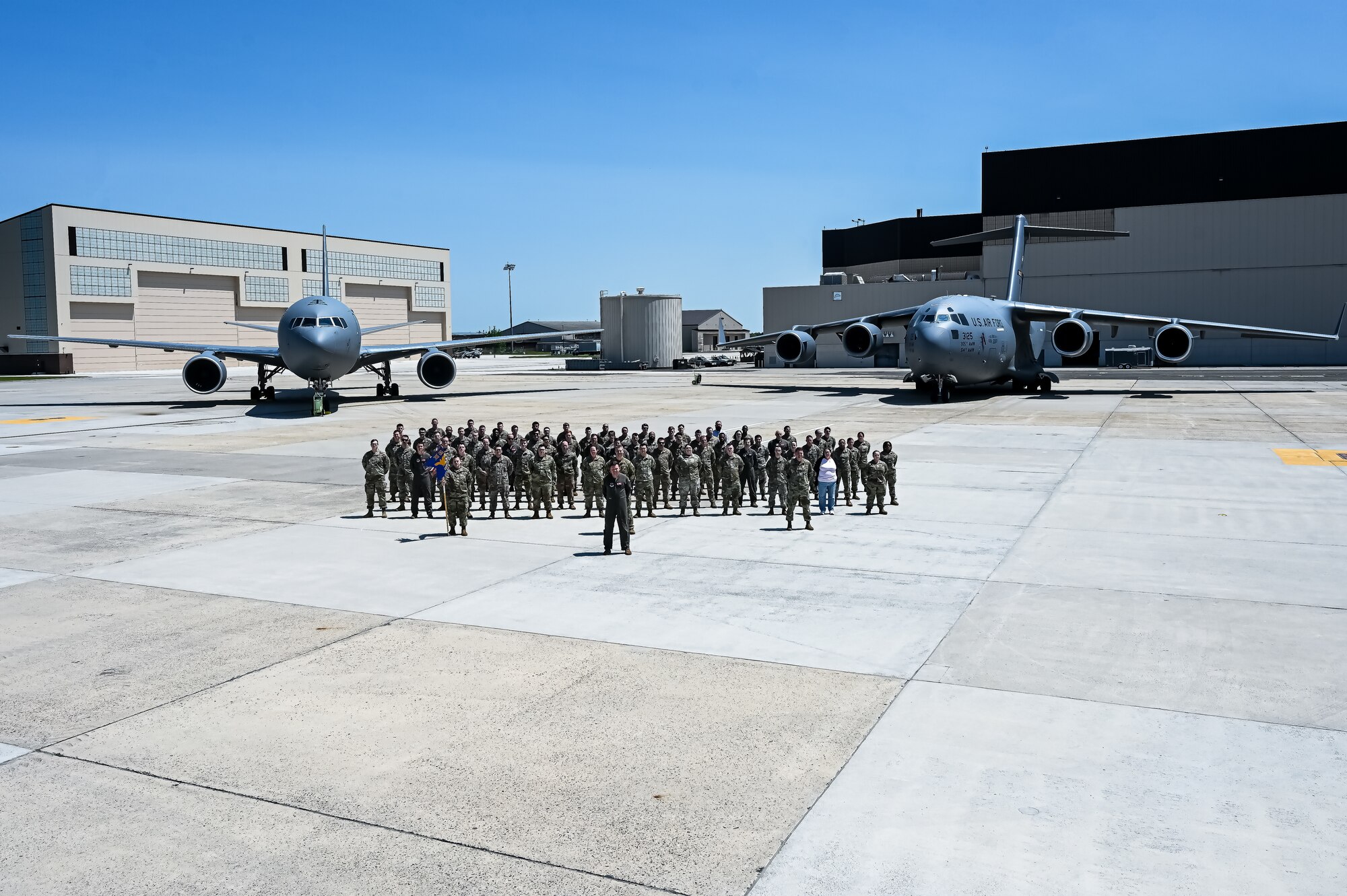U.S. Air Force Airmen assigned to the 305th Air Mobility Wing pose for a flight line photo on 10 May, 2023 at Joint Base McGuire-Dix-Lakehurst, N.J. The 305th AMW extends America's global reach by generating, mobilizing and deploying KC-10 Extenders and C-17 Globemaster III’s to conduct strategic airlift and air refueling missions worldwide. In November 2021, the wing began transitioning to the new KC-46A Pegasus air refueling aircraft. Additionally, the Wing operates two of America's largest strategic aerial ports supporting the delivery of cargo and personnel to combatant commanders abroad.