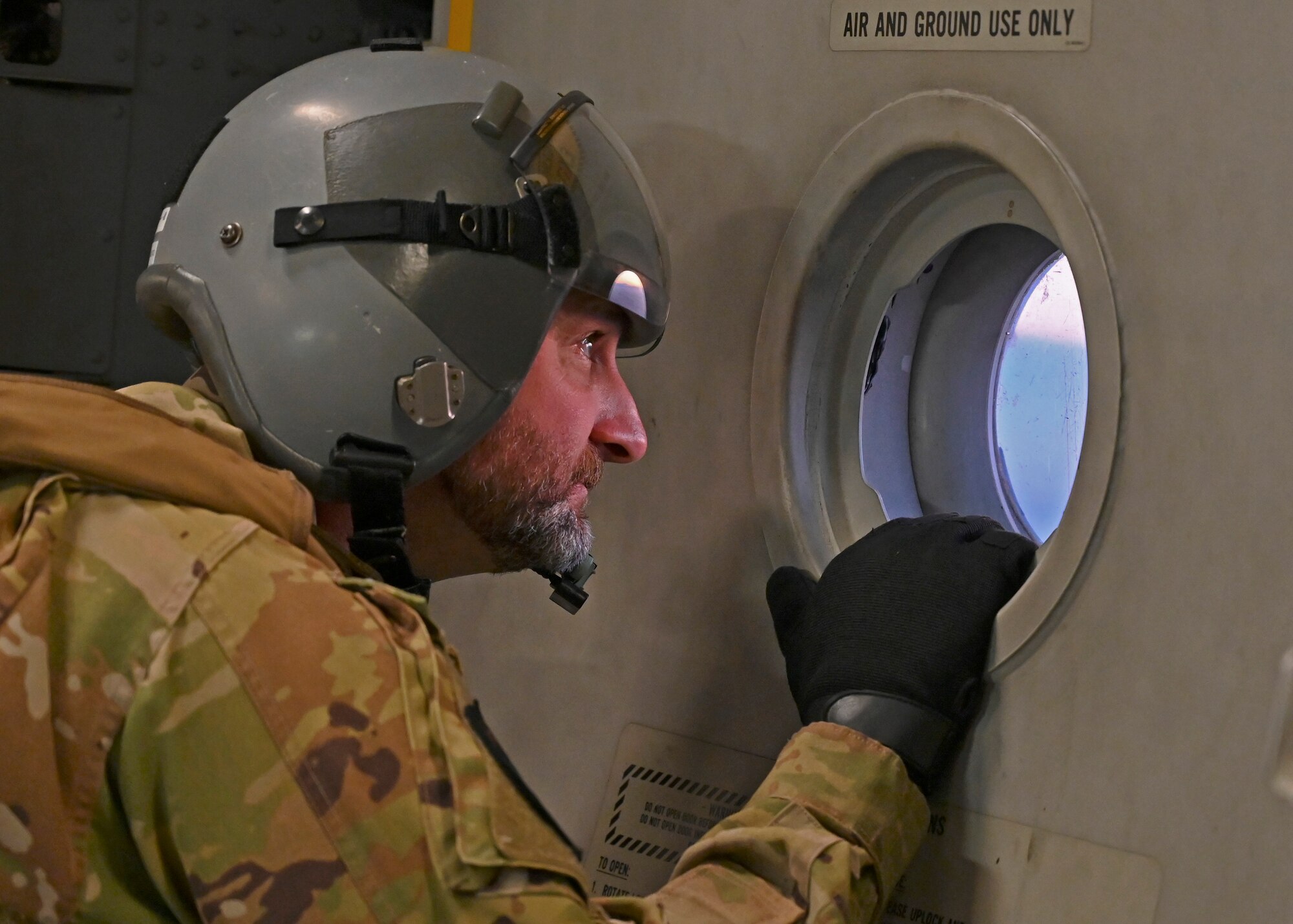 U.S Air Force Master Sgt. Kent Koerner, loadmaster with the 7th Expeditionary Airlift Squadron, looks out the troop door window on a C-17 Globemaster III assigned to Joint Base Lewis-McChord, Washington, during DEFENDER 23 at Base Aerea De Zaragoza, Spain, May 10, 2023. DEFENDER 23 is a U.S. Army Europe and Africa-led exercise, supported by U.S. Air Forces in Europe – Air Forces Africa, focused on the strategic deployment of continental United States-based forces and interoperability with Allies and partners. Taking place from April 22 to June 23, DEFENDER 23 demonstrates the U.S. Air Force’s ability to aggregate U.S.-based combat power quickly in Europe; increase lethality of the NATO Alliance through the U.S. Air Force’s Agile Combat Employment; build unit readiness in a complex joint, multi-national environment; and leverage host nation capabilities to increase USAFE-AFAFRICA’s operational reach. DEFENDER 23 includes more than 7,800 U.S. and 15,000 multi-national service members from various Allied and partner nations. (U.S Air Force photo by Senior Airman Callie Norton)