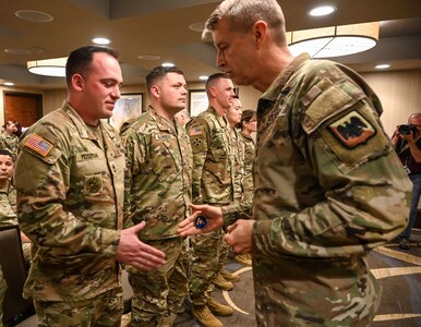 Gen. Daniel R. Hokanson, chief of the National Guard Bureau, presents a coin to Sgt. 1st Class Brandon Moseman in Saratoga Springs, New York, May 10, 2023. National Guard Bureau leaders recognized recognize recruiters for making New York the only state to exceed its recruiting goals for the year.