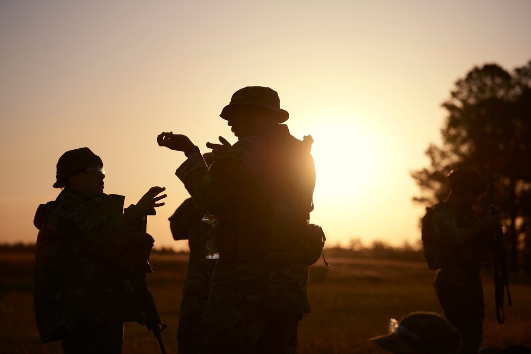 Photo of Marksmanship team members from the Vermont Air National Guard's 158th Fighter Wing, discussing strategy and techniques during a team event at the Winston P. Wilson competition at Camp Robinson, Arkansas, May 4, 2023.