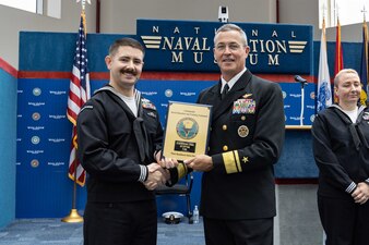 Rear Adm. Pete Garvin, right, commander, Naval Education and Training Command (NETC), awards a plaque to Equipment Operator First Class Kohl J. Chrislock, assigned to Center for Seabees and Facilities Engineering Gulfport, Mississippi, one of NETC’s fiscal year 2022 Sailor of the Year (SOY) finalists, during NETC’s SOY announcement and award ceremony at the National Naval Aviation Museum in Pensacola, Florida, May 11, 2023. NETC's mission is to recruit, train and deliver those who serve our nation, taking them from street-to-fleet by forging civilians into highly skilled, operational and combat ready warfighters. (United States Navy photo by Mass Communication Specialist 2nd Class Zachary Melvin)