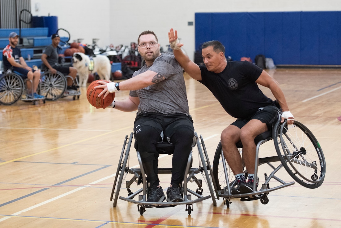 An RSM tips his wheelchair into another attempting to shoot during wheelchair basketball.