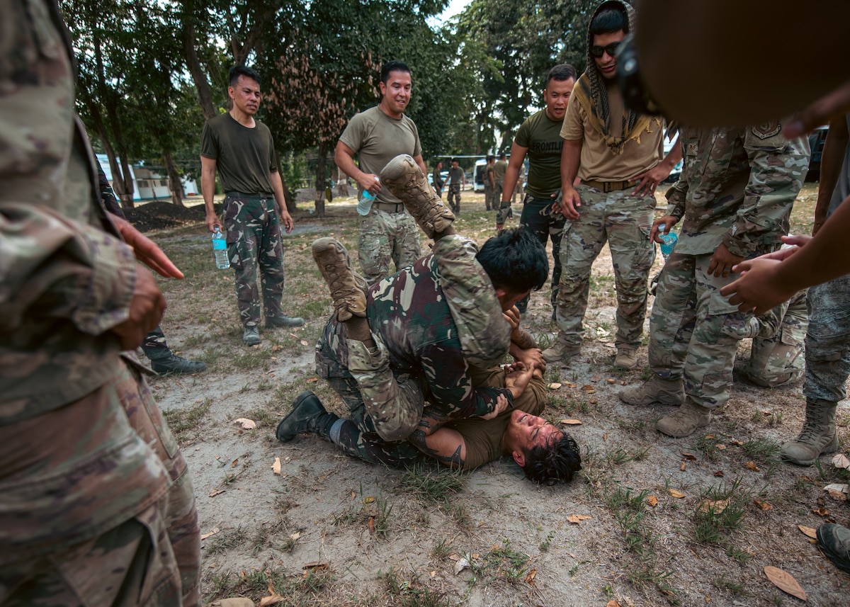 Senior Airman Christian Melliza, 736th Security Forces Squadron commando warrior instructor, and a Philippine Air Force member practice combatives during subject matter expert exchanges as part of exercise Cope Thunder at Basa Air Base, Philippines, May 5, 2023. Training exercises like these enhance capability and interoperability, while strengthening trust between like-minded nations to ensure the air, maritime, cyber and space domains remain open to all nations. (U.S. Air Force photo by Senior Airman Sebastian Romawac)