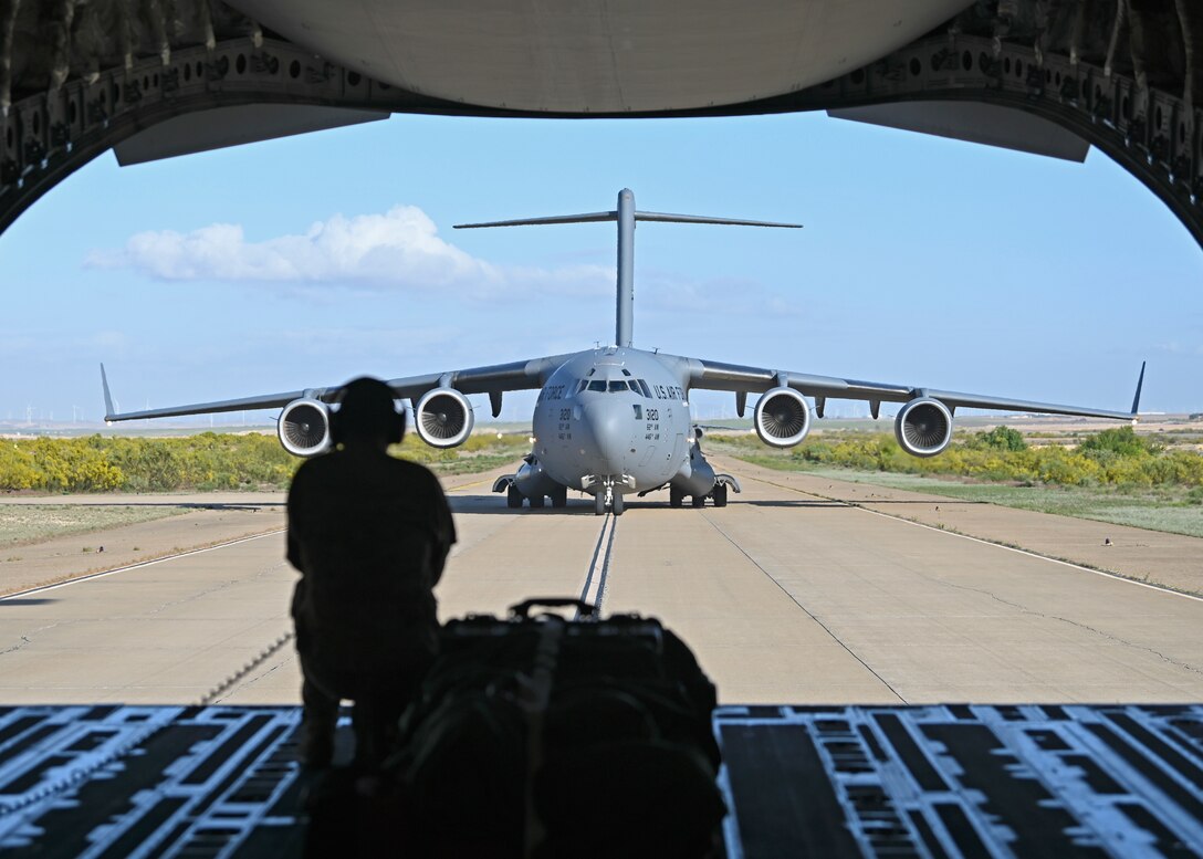 U.S Air Force Master Sgt. Kent Koerner, loadmaster with the 7th Expeditionary Airlift Squadron, views a C-17 Globemaster III assigned to Joint Base Lewis-McChord, Washington, from the ramp of a C-17 during DEFENDER 23 at Base Aerea De Zaragoza, Spain, May 10, 2023. DEFENDER 23 is a U.S. Army Europe and Africa-led exercise, supported by U.S. Air Forces in Europe – Air Forces Africa, focused on the strategic deployment of continental United States-based forces and interoperability with Allies and partners. Taking place from April 22 to June 23, DEFENDER 23 demonstrates the U.S. Air Force’s ability to aggregate U.S.-based combat power quickly in Europe; increase lethality of the NATO Alliance through the U.S. Air Force’s Agile Combat Employment; build unit readiness in a complex joint, multi-national environment; and leverage host nation capabilities to increase USAFE-AFAFRICA’s operational reach. DEFENDER 23 includes more than 7,800 U.S. and 15,000 multi-national service members from various Allied and partner nations. (U.S Air Force photo by Senior Airman Callie Norton)