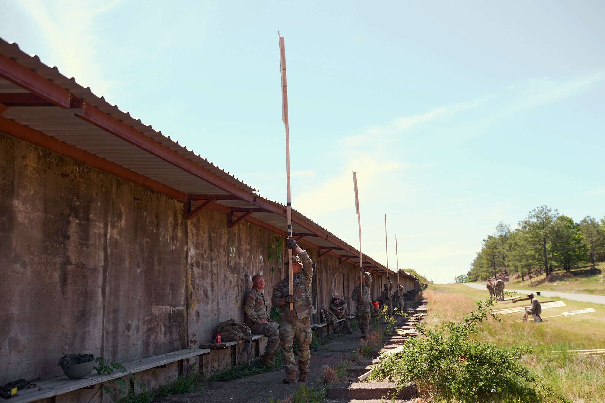 Photo of Cadre members pacing back and fourth with targets for a rfile event during the Winston P. Wilson competition at Camp Robinson, Arkansas, May 3, 2023.
