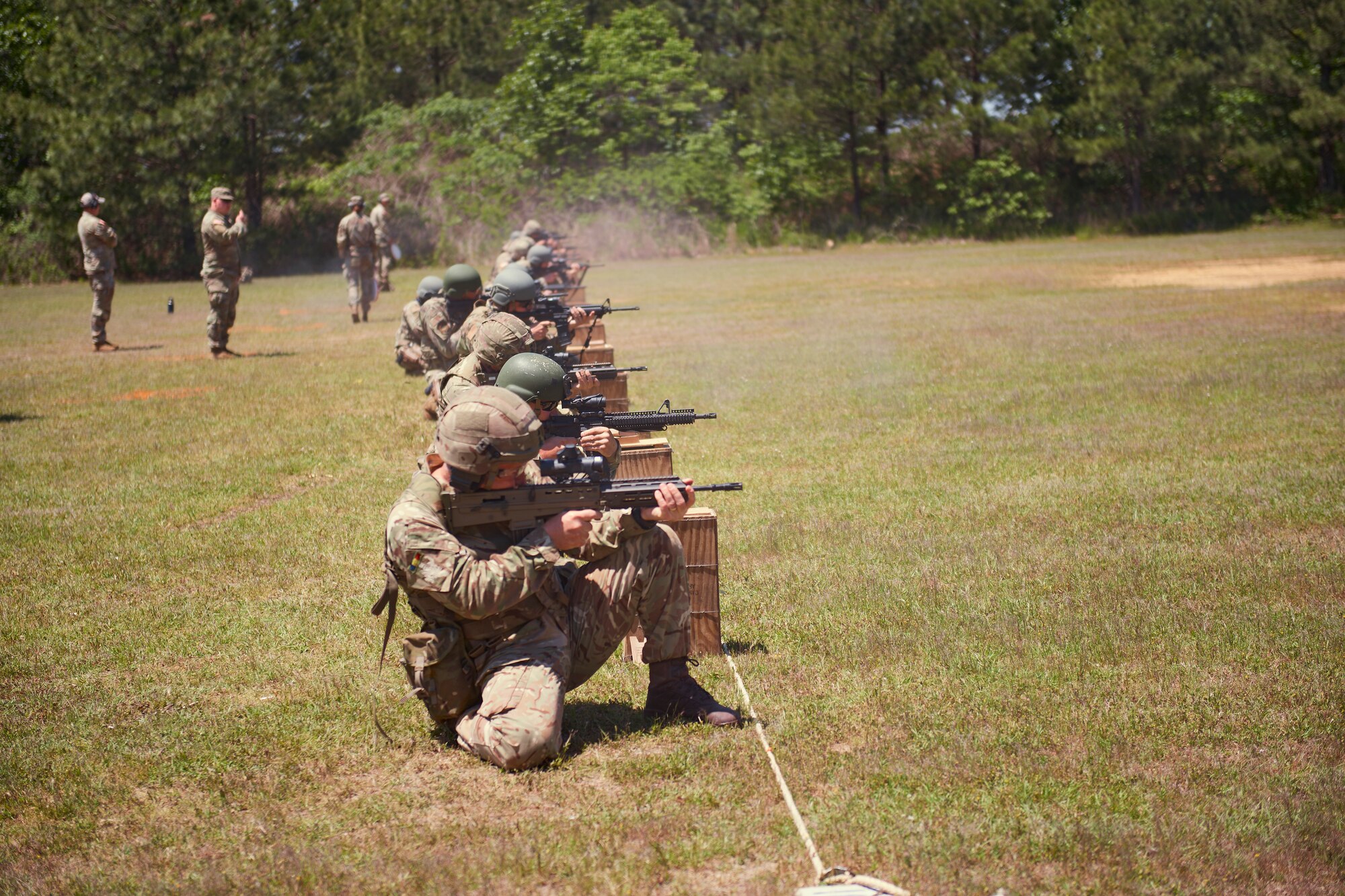 Competitors shoot from the kneeling position during a team event at the Winston P. Wilson competition at Camp Robinson, Arkansas, May 3, 2023.