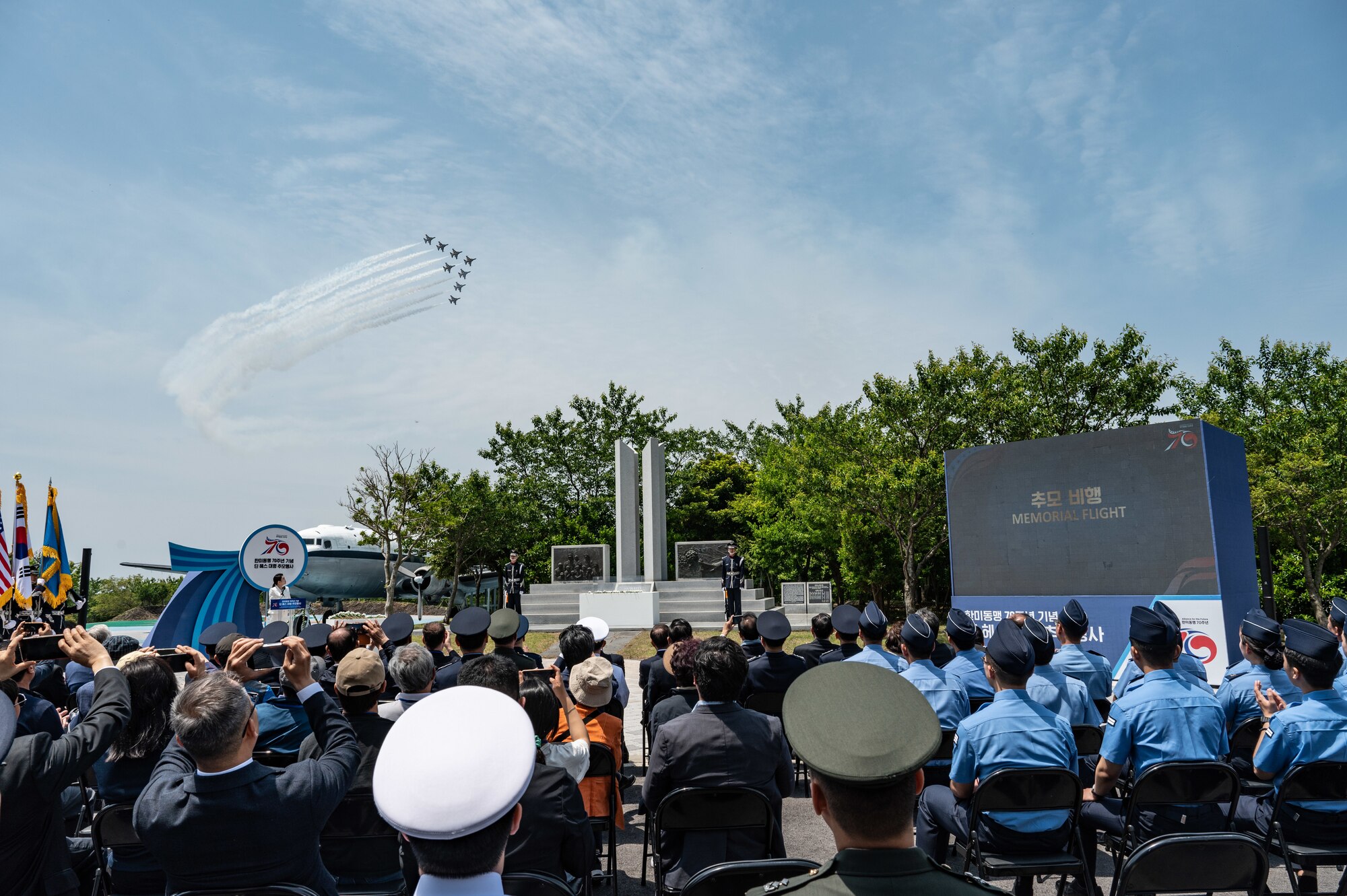 United States and Republic of Korea members watch the ROK aerobatic team, the Black Eagles, perform an aerial maneuver to honor retired Col. Dean Hess during a commemorative ceremony at Jeju Aerospace Museum, Jeju, Republic of Korea, May 11, 2023