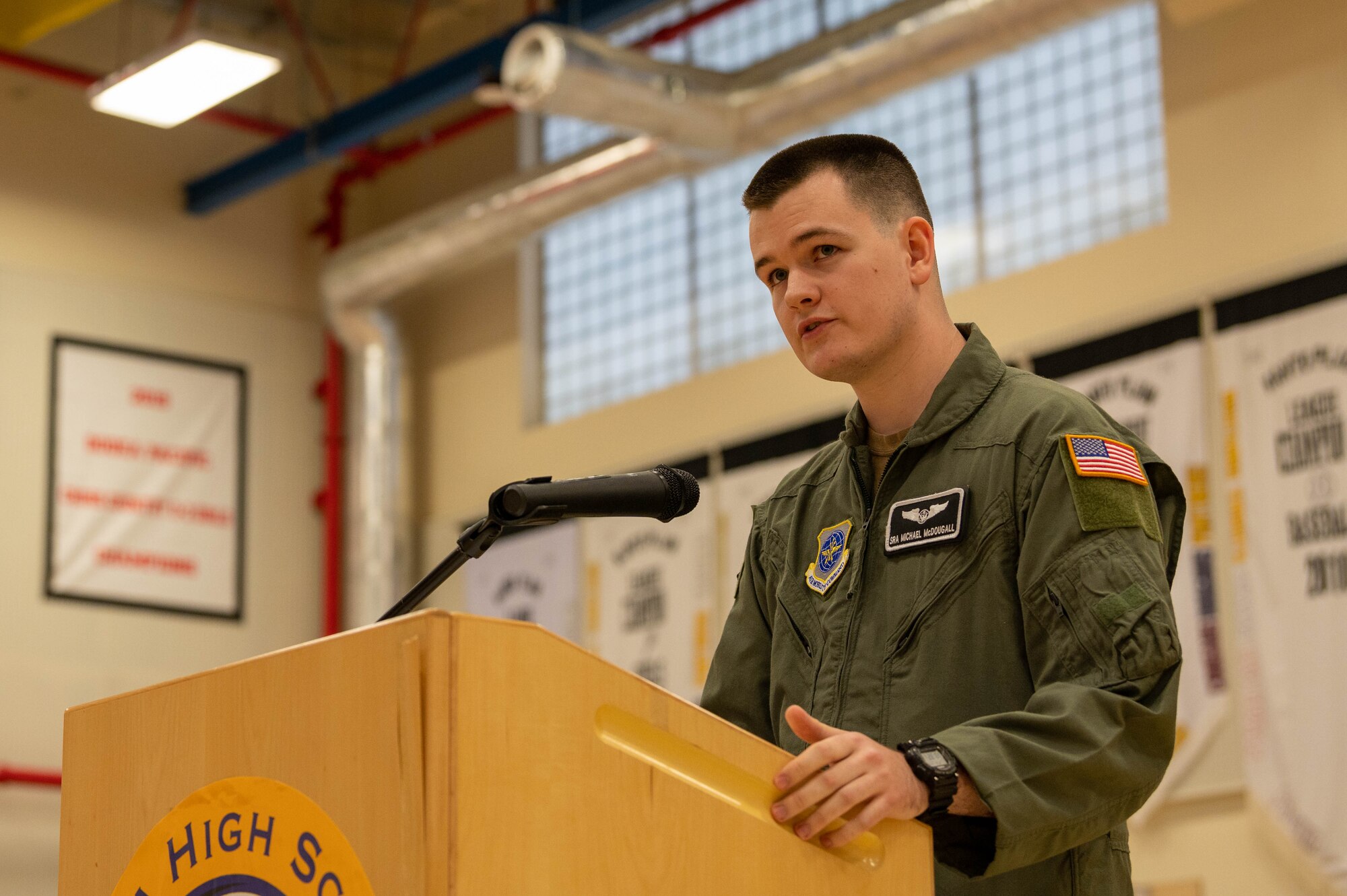 A service member delivers remarks during a combat flag presentation ceremony.