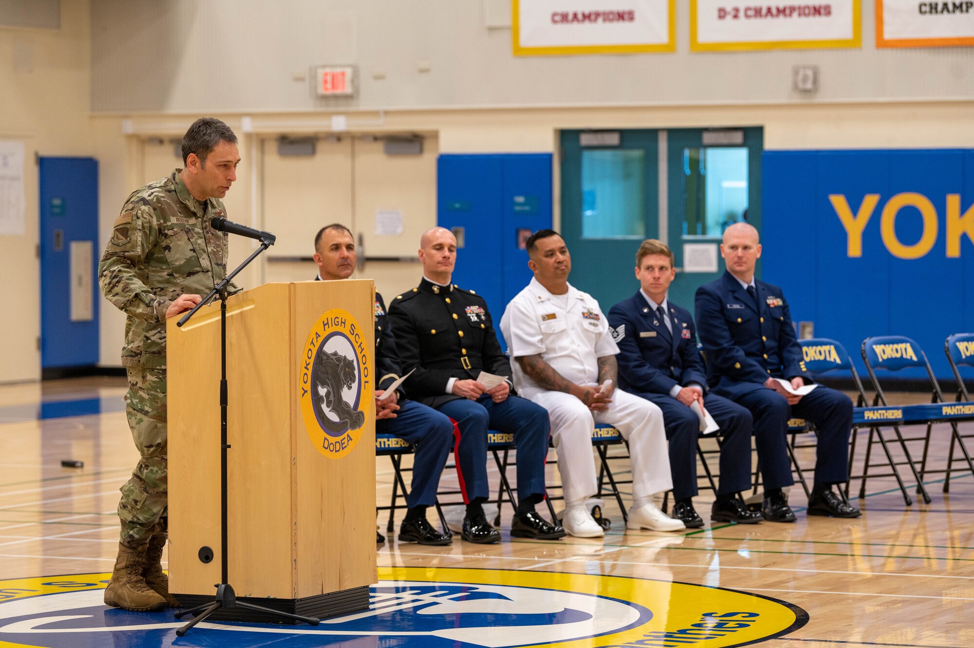 A service member delivers the closing remarks following a combat flag presentation ceremony.