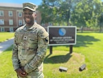 A Soldier poses in front of a sign.