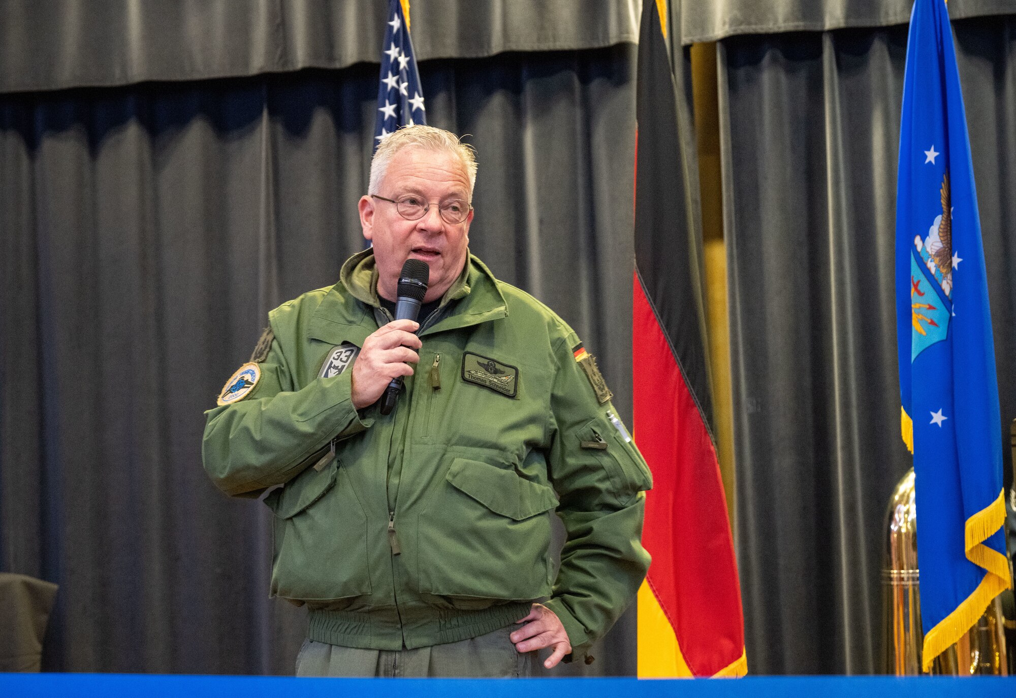 German Air Force Col. Thomas Schneider, Tactical Air Wing 33 commander at Buchel Air Base, Germany, gives a speech during Explore the Eifel May 12, 2023, at Spangdahlem Air Base, Germany. Spangdahlem AB hosted the Explore the Eifel event to promote partnership with the local community and celebrate major milestones. (U.S. Air Force photo by Senior Airman Jessica Sanchez-Chen)