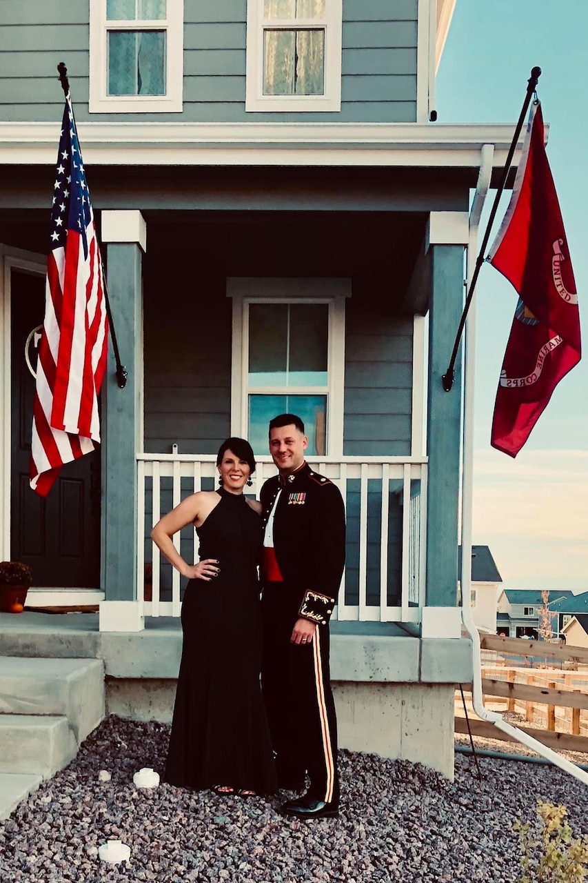 A Marine Corps member poses in formal uniform with his wife.