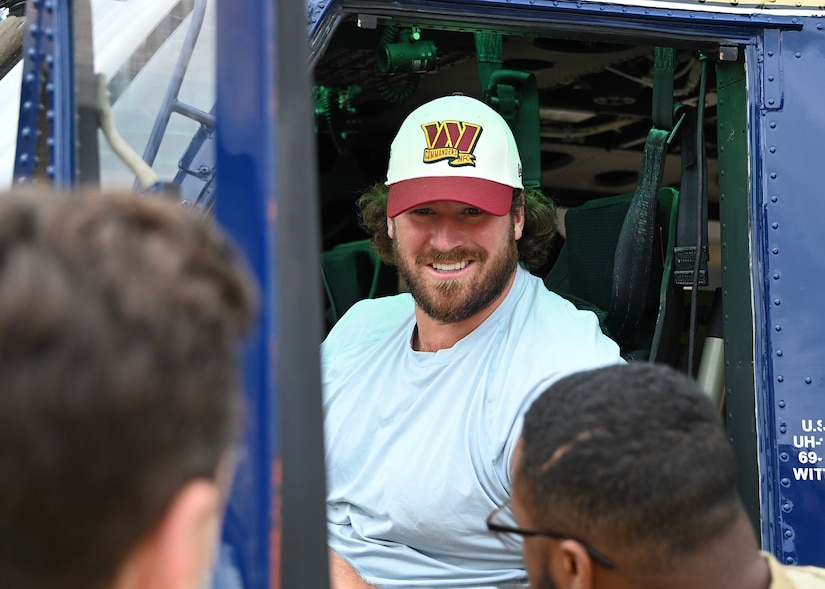 A man with a hat sits in a helicpter.