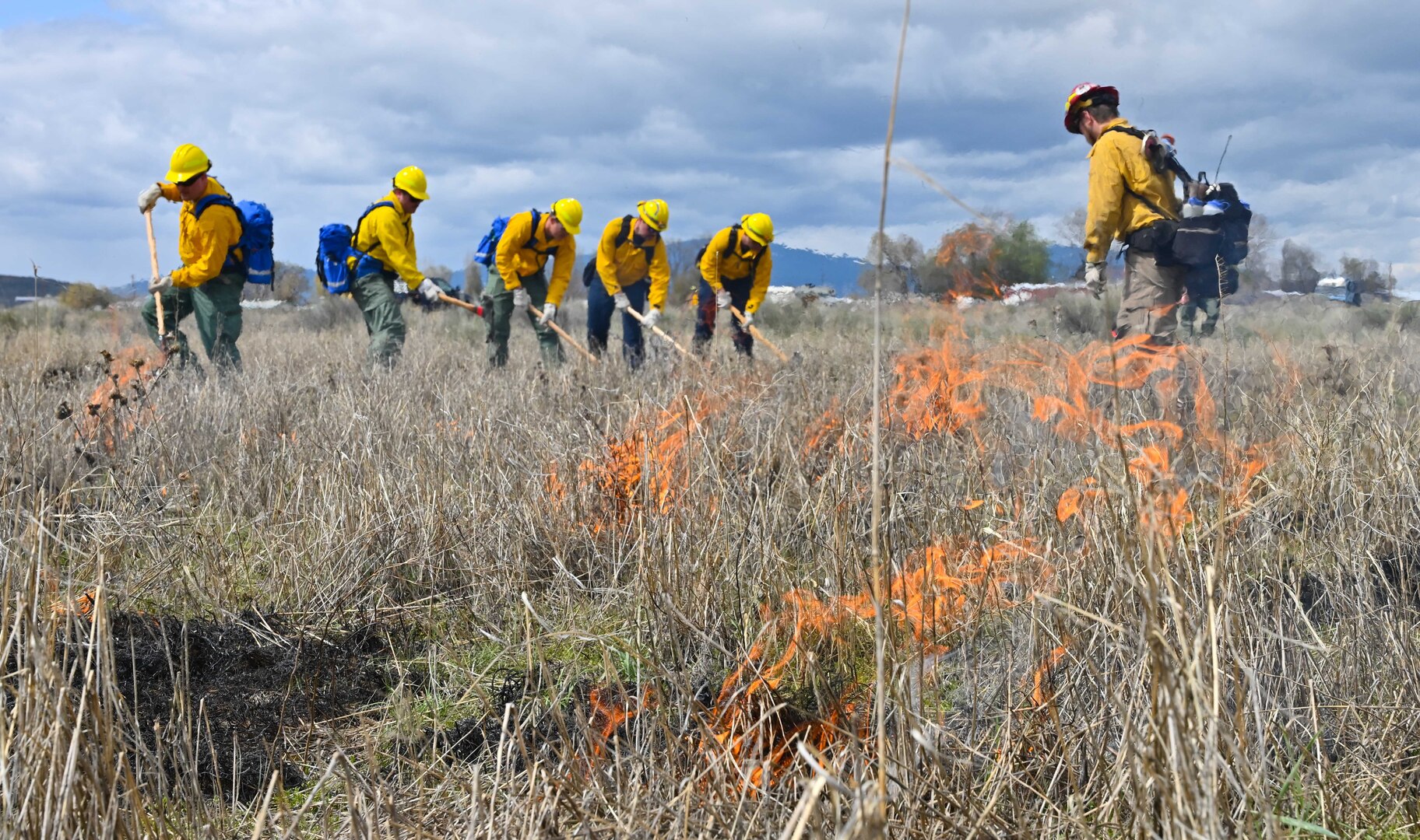 Airmen assigned to the 173rd Fighter Wing don Oregon Department of Forestry uniforms and extinguish a grass fire during wildland firefighter training at Kingsley Field in Klamath Falls, Ore., May 7, 2023. The training prepared Oregon Air Guardsmen to aid the state when wildland fires outpace state resources during hot summer months.