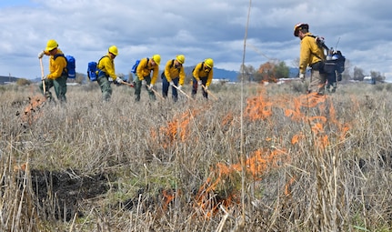 Airmen assigned to the 173rd Fighter Wing don Oregon Department of Forestry uniforms and extinguish a grass fire during wildland firefighter training at Kingsley Field in Klamath Falls, Ore., May 7, 2023. The training prepared Oregon Air Guardsmen to aid the state when wildland fires outpace state resources during hot summer months.