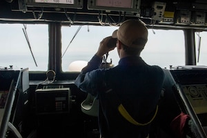 230509-N-NH267-1023 ARABIAN GULF (May 9, 2023) Ensign Gordon Kitchener looks out from the bridge of the guided-missile destroyer USS Paul Hamilton (DDG 60), May 9, 2023 in the Arabian Gulf. Paul Hamilton is deployed to the U.S. 5th Fleet area of operations to help ensure maritime security and stability in the Middle East region.