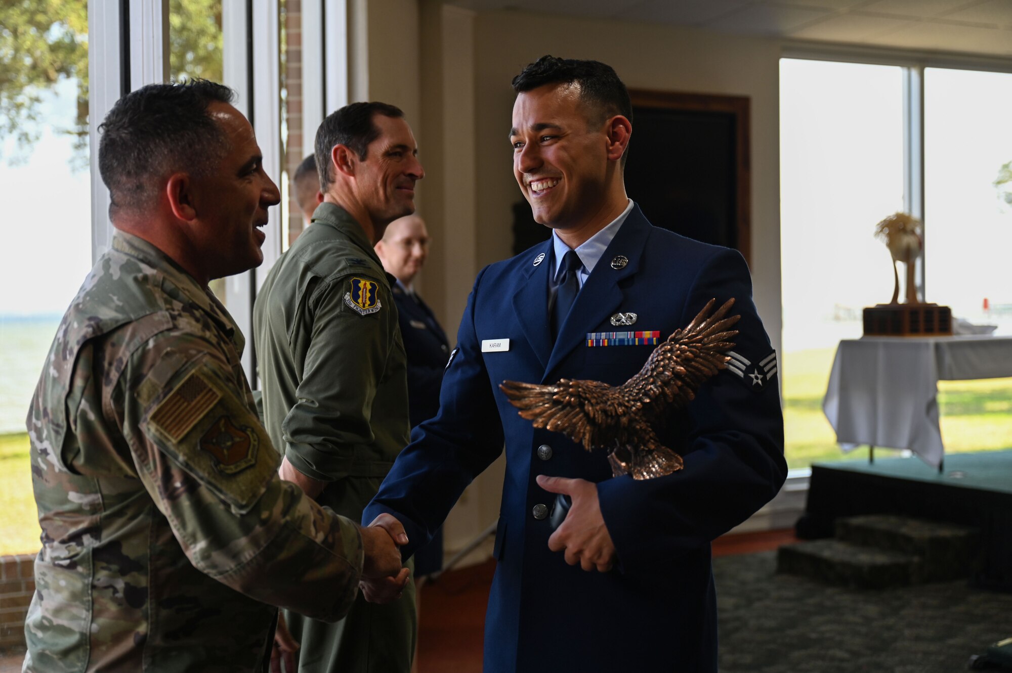 Senior Airman Anthony Karam, 16th Electronic Warfare Squadron avionics technician, right, shakes U.S. Air Force Col. Josh Koslov, 350th Spectrum Warfare commander, left, during Airman Leadership School (ALS) class 23-D graduation at Eglin Air Force Base, Fla., May 11, 2023. Karama won the John L. Levitow Award, which is the highest award for enlisted Professional Military Education in the Air Force. (U.S. Air Force photo by Staff Sgt. Ericka A. Woolever)