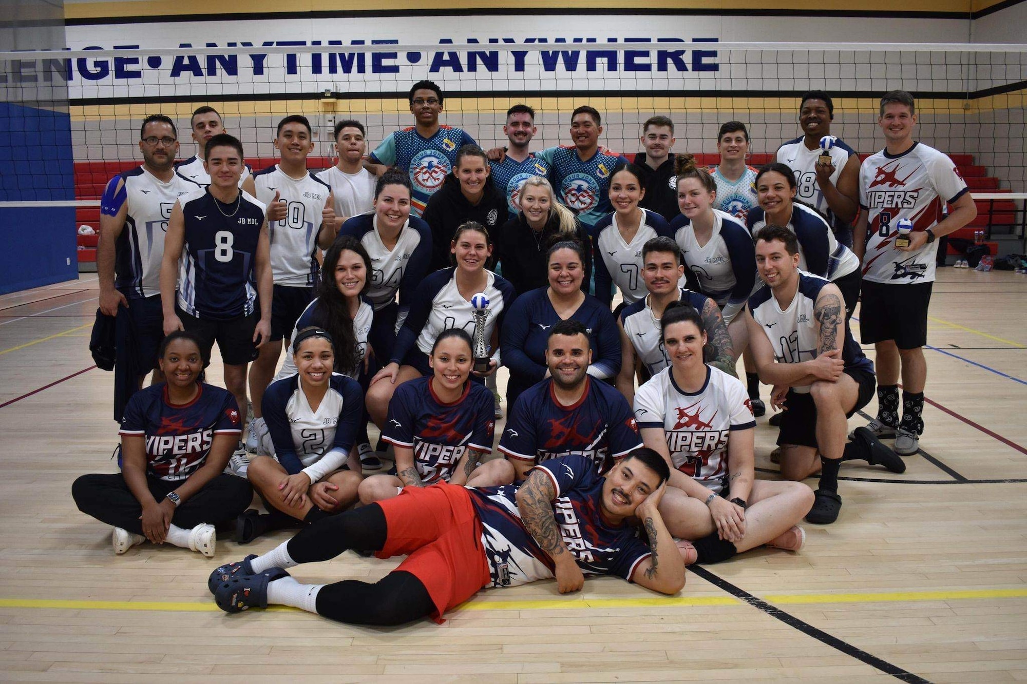 The Joint Base McGuire-Dix-Lakehurst travel volleyball team poses for a photo with members from Shaw Air Force Base and Seymour Johnson Air Force Base during volleyball tournament.