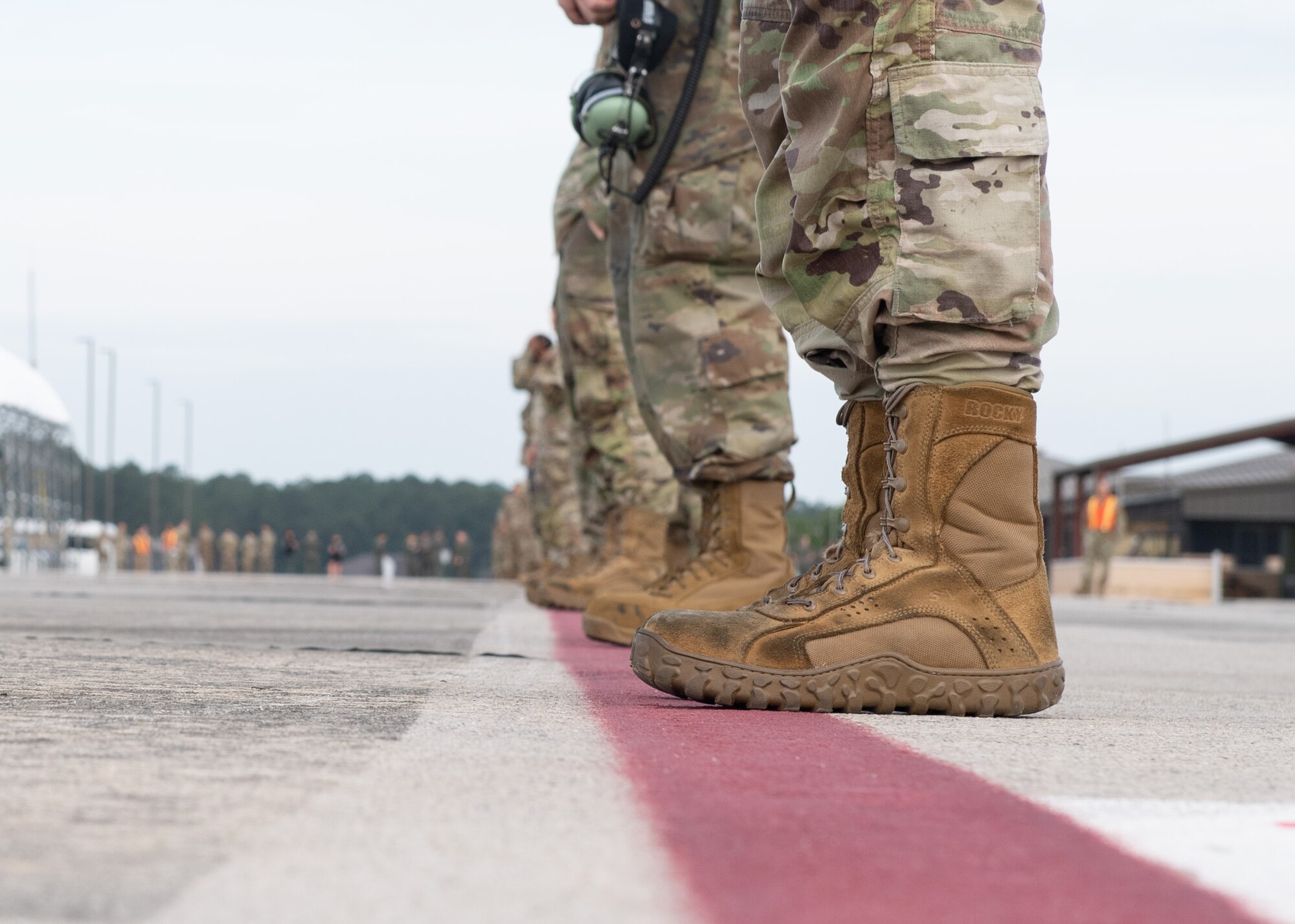 Airmen line up along the flight line.