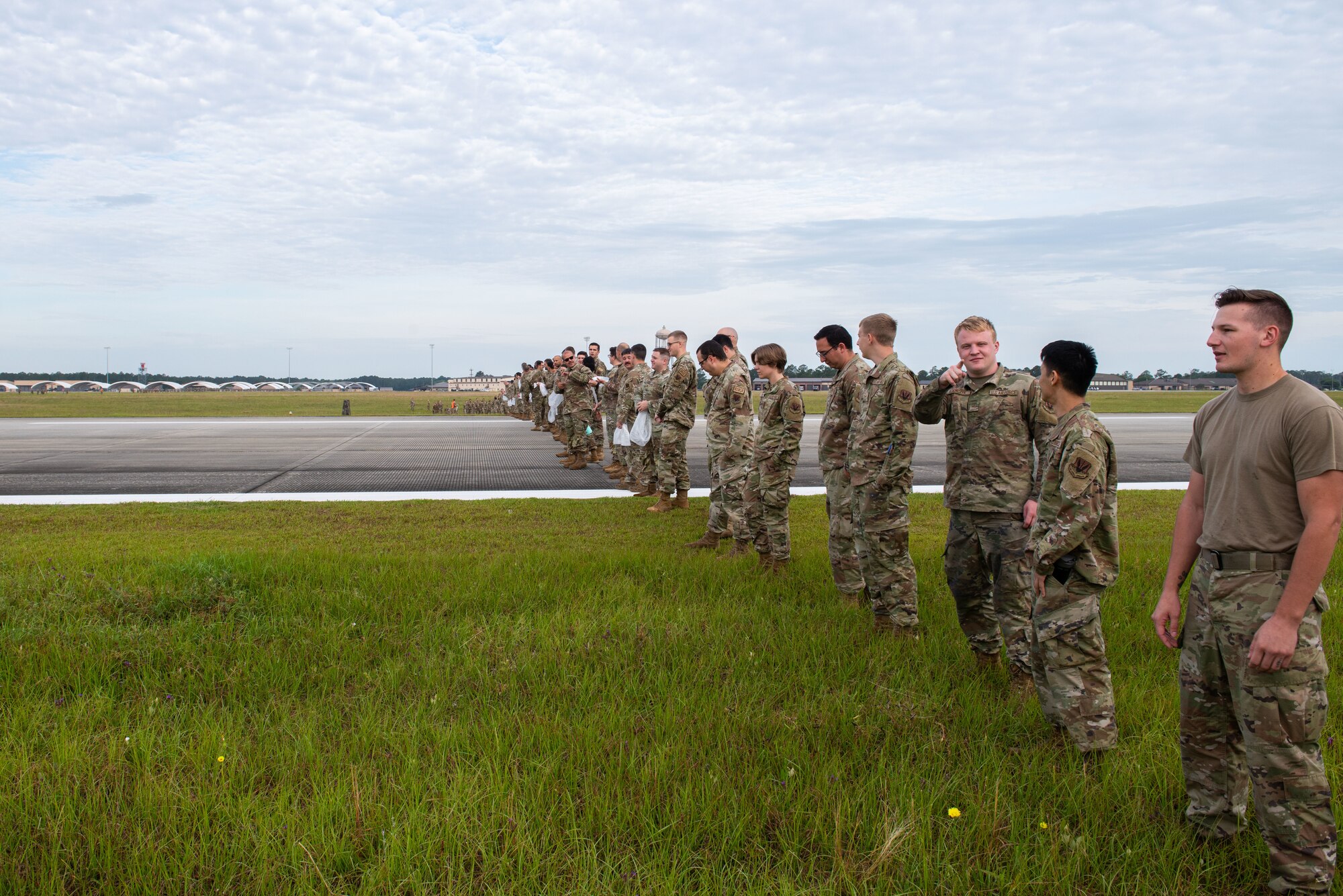 Airmen line up across the flight line.