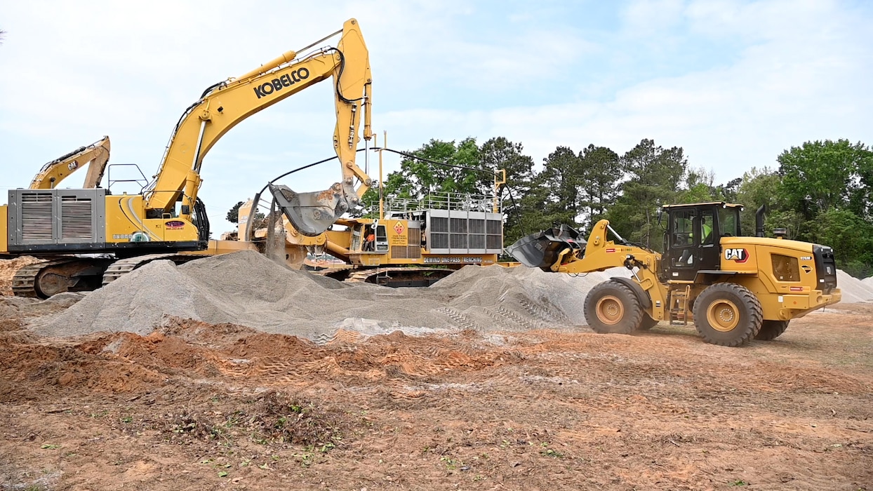 Excavator equipment sits on piles of dirt and gravel outside