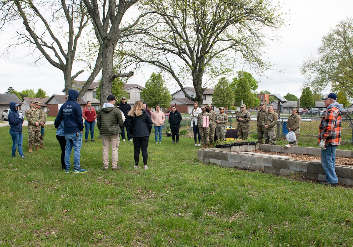 A group of Airmen and civilians gather around the Butterfly Garden May 03, 2023, at Wright-Patterson Air Force Base, Ohio. The pollinator garden provides a memorial space for parents who have experienced the loss of a pregnancy or child. (U.S. Air Force photo by Airman 1st Class Elizabeth Figueroa)