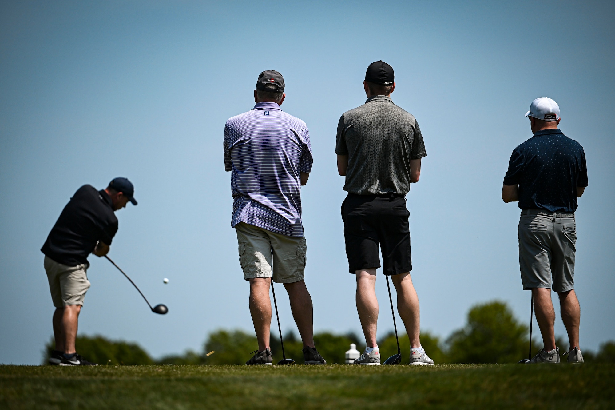 A group of participants watch as a teammate tees off during the Bluesuiters Golf Tournament at Jonathan’s Landing Golf Course in Magnolia, Delaware, May 11, 2023. Bluesuiters is a biannual golf tournament aimed at connecting Team Dover Airmen with local civic and business leaders. (U.S. Air Force photo by Staff Sgt. Marco A. Gomez)