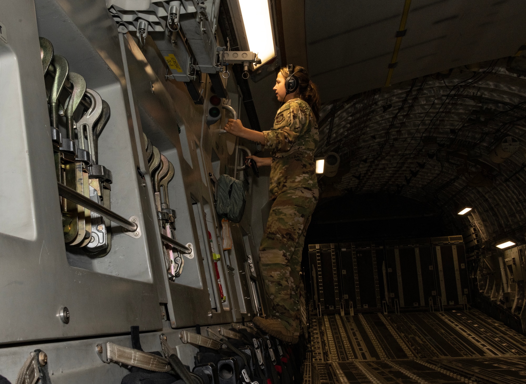 An Airman looks through the window of an aircraft in flight.