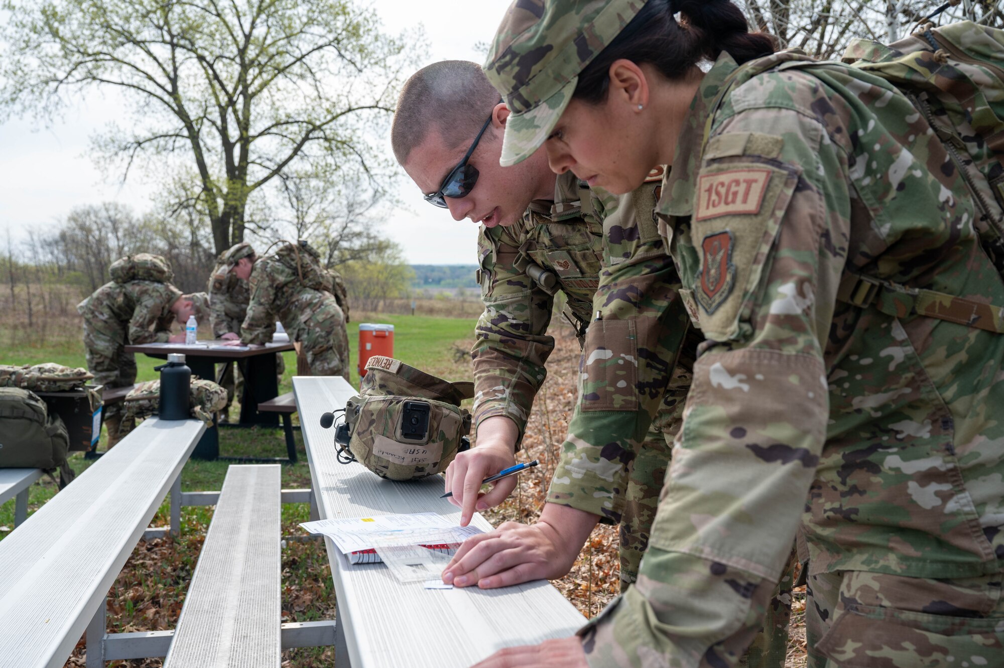 Master Sgt. Robin Barber, the 934th Security Forces Squadron 1st Sgt., right, and Staff Sgt. Ian Reynolds, a 934 SFS specialist, plot out a path on a map for a land navigation exercise at Arden Hills, Minnesota, May 7, 2023. The 934 SFS conducted a routine land navigation course to refresh and brush up on the arduous process of using a compass and pace count. (U.S. Air Force photo by Senior Airman Matthew Reisdorf)