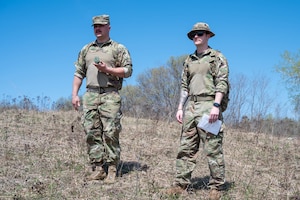 Senior Airman Tucker Lemmerman, left, and Senior Airman Avery Tillery, both 934th Security Forces Squadron specialists, check their surroundings during a land navigation course at Arden Hills, Minnesota, May 7, 2023. The 934 SFS conducted a routine land navigation course to refresh and brush up on the arduous process of using a compass and pace count. (U.S. Air Force photo by Senior Airman Matthew Reisdorf)