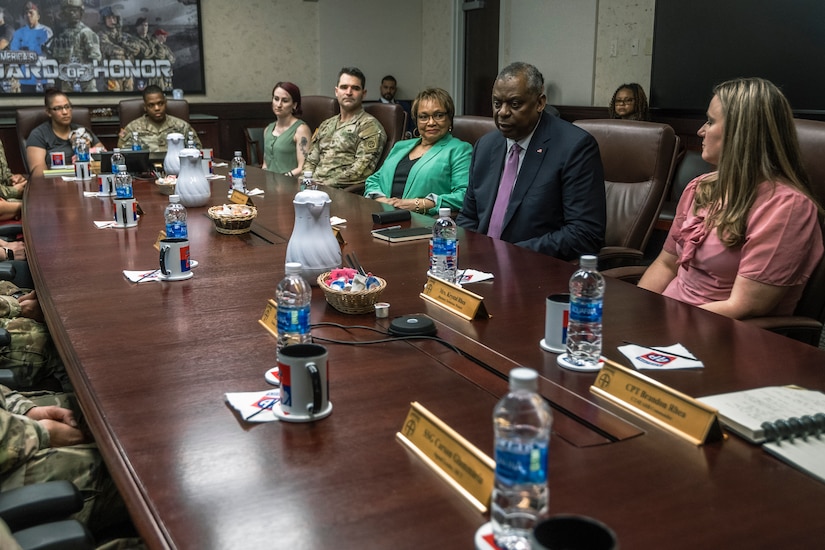 Many people sit at a long conference table.