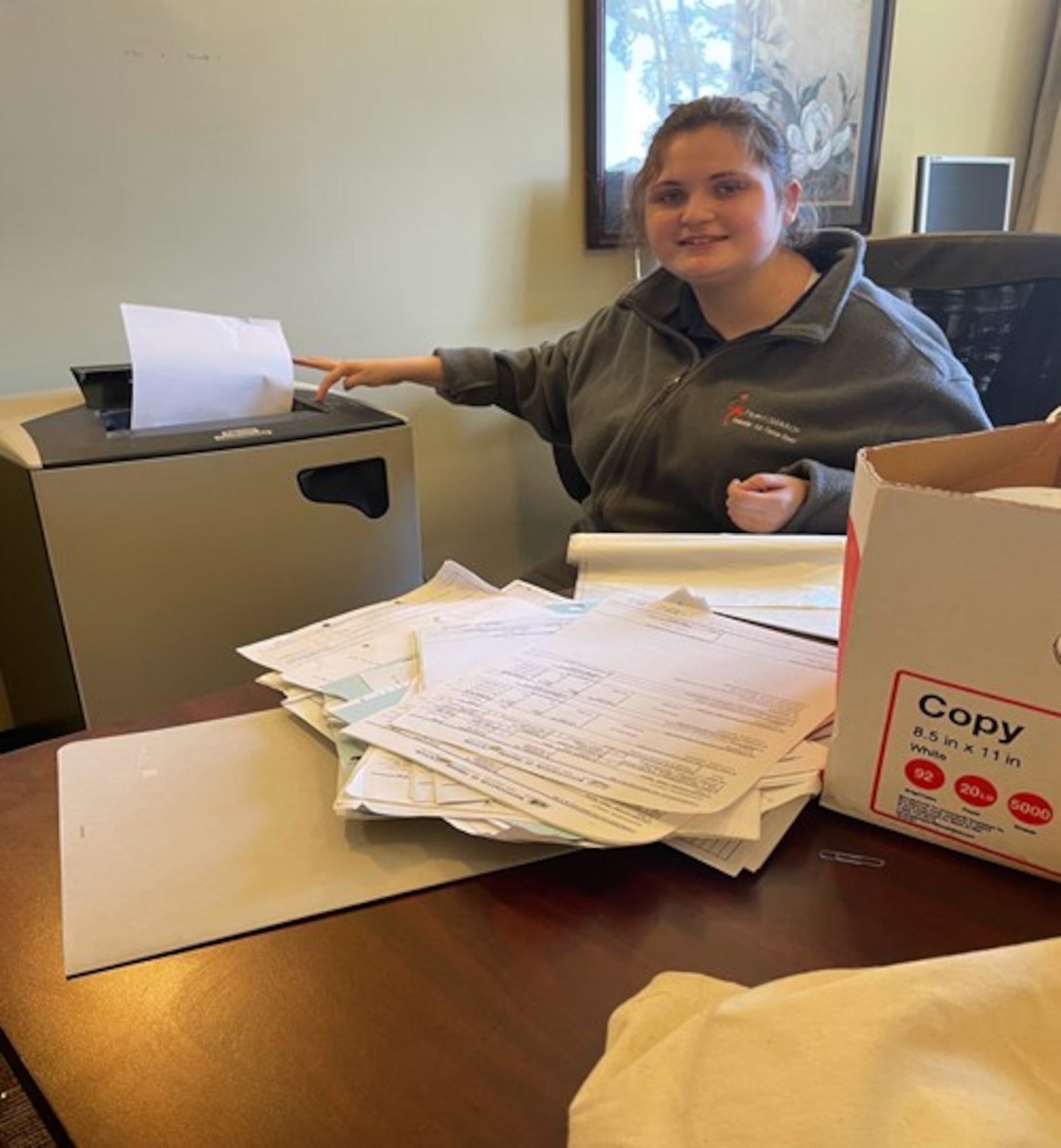 Courtesy photo of Candace Taylor, Project SEARCH intern, shredding paper at Tyer House while working with Keesler Air Force Base Lodging.