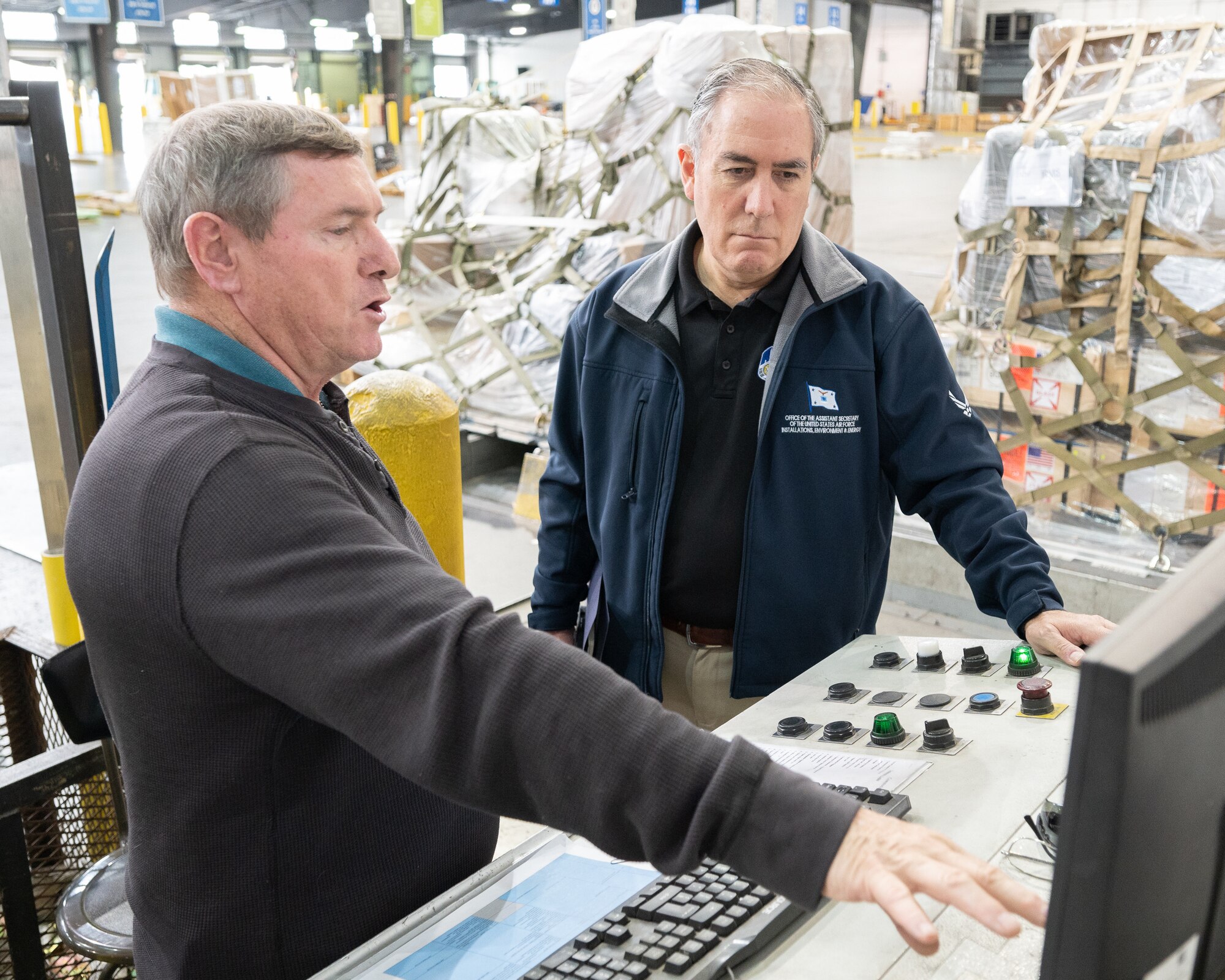 From the right, Roberto Guerrero, Deputy Assistant Secretary of the Air Force, speaks with Michael Williams, 436th Aerial Port Squadron air freight operations manager, about the Inventory Control System at Dover Air Force Base, Delaware, May 7, 2023. Guerrero toured various units to help identify obstacles associated with everyday logistical tasks vital to combat mission accomplishment. (U.S. Air Force photo by Mauricio Campino)