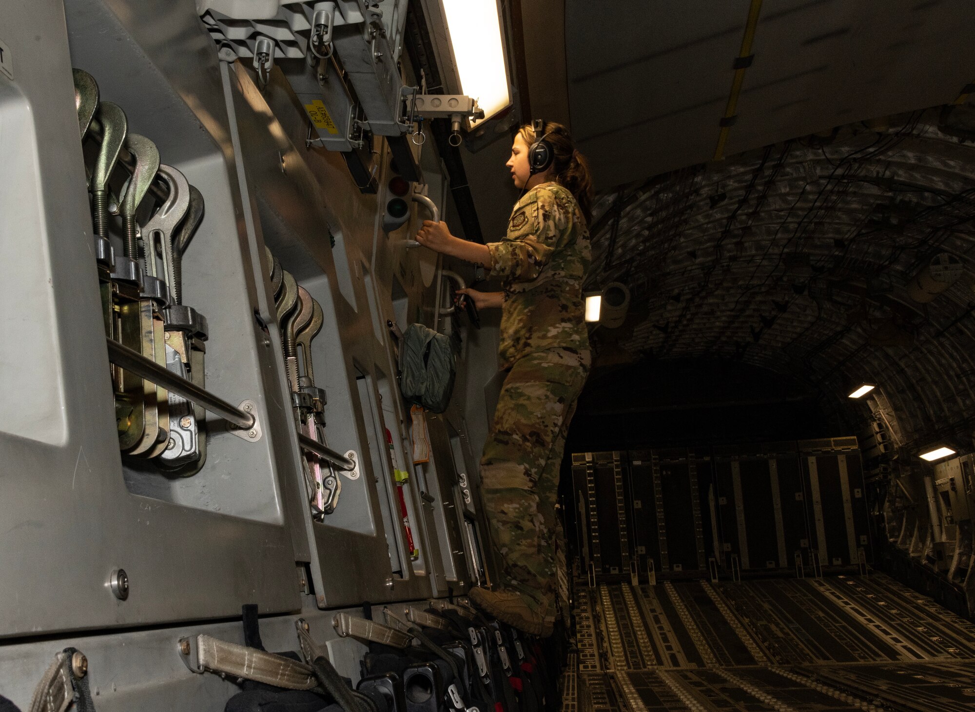 An Airman looks through the window of an aircraft in flight.