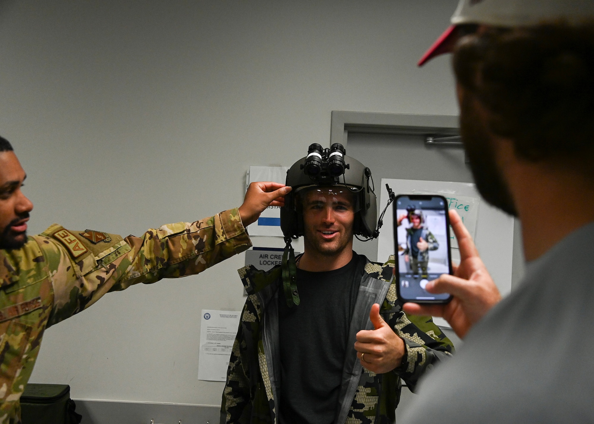 Jake Fromm, Washington Commander player, tries on a helmet worn by the pilots of the 1st Helicopter Squadron at Joint Base Andrews, Md., May 9, 2023.