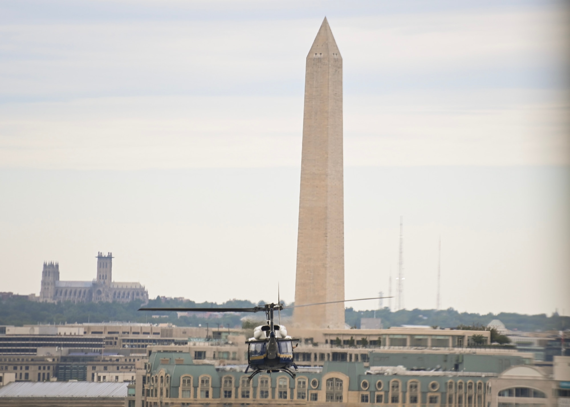 A helicopter flies towards the Washington Monument in Washington D.C.