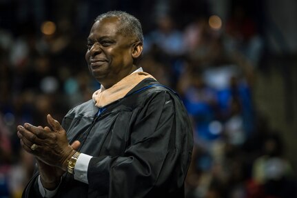 Secretary of Defense Lloyd J. Austin III claps his hands and smiles during  a speech.