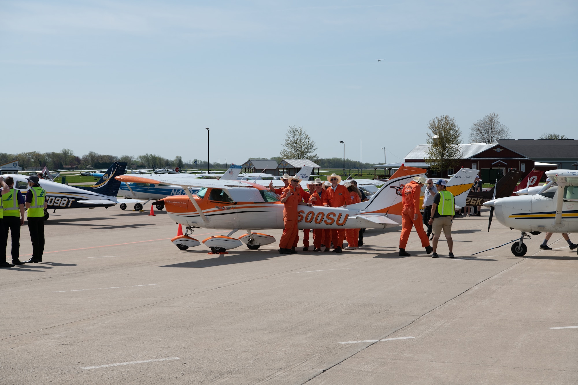 Collegiate aviators stand by an aircraft in preparation for competition