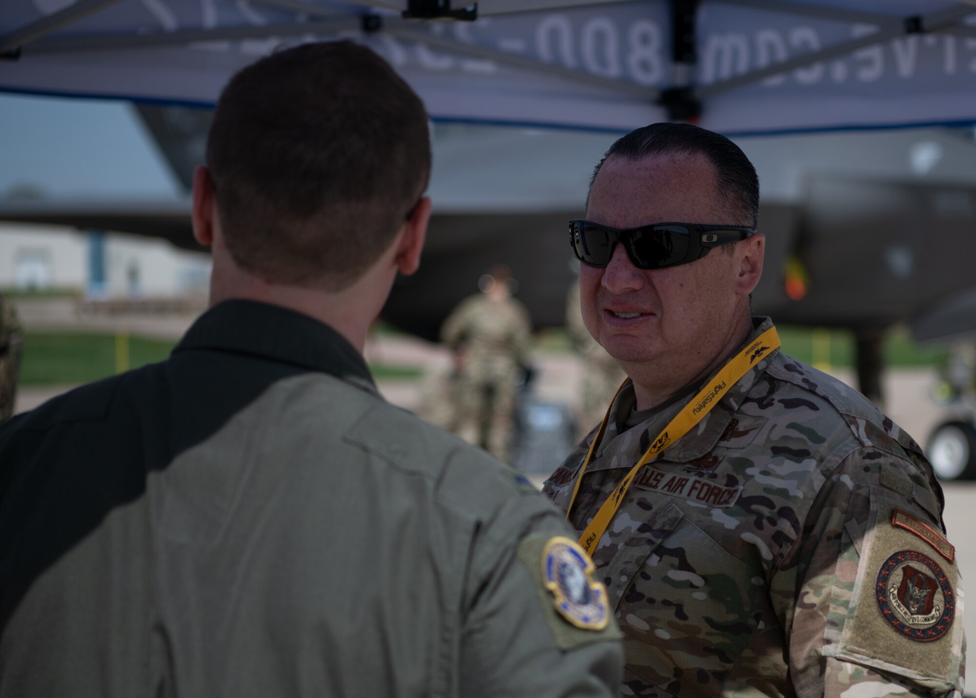 Two Air Force Reserve officers are talking on a flight line
