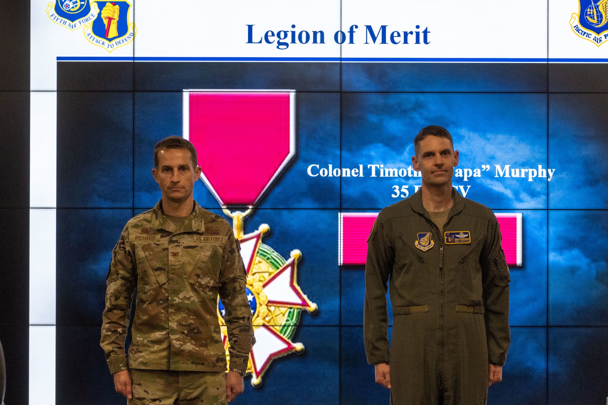 U.S. Air Force Col. Michael Richard, 35th Fighter Wing (FW) commander, and Col. Timothy Murphy, 35th FW vice commander, stand at attention while Murphy receives the Legion of Merit Medal at Misawa Air Base, Japan, May 4, 2023.