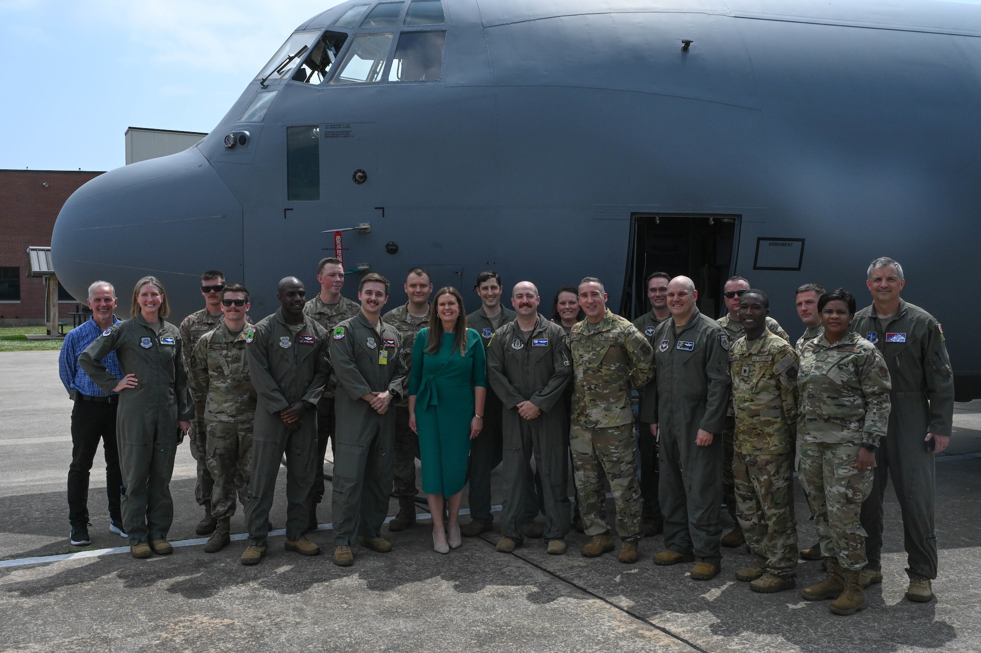 Men and women in uniform pose for a photo in front of a plane.
